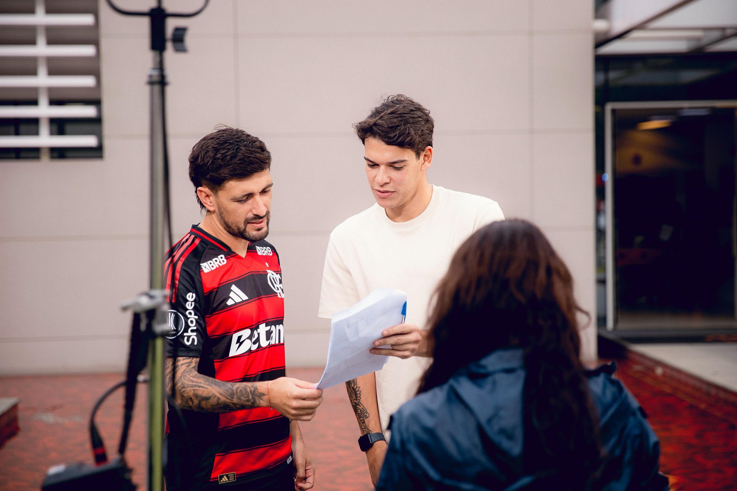Jogador do Flamengo lê o roteiro com a equipe durante a gravação