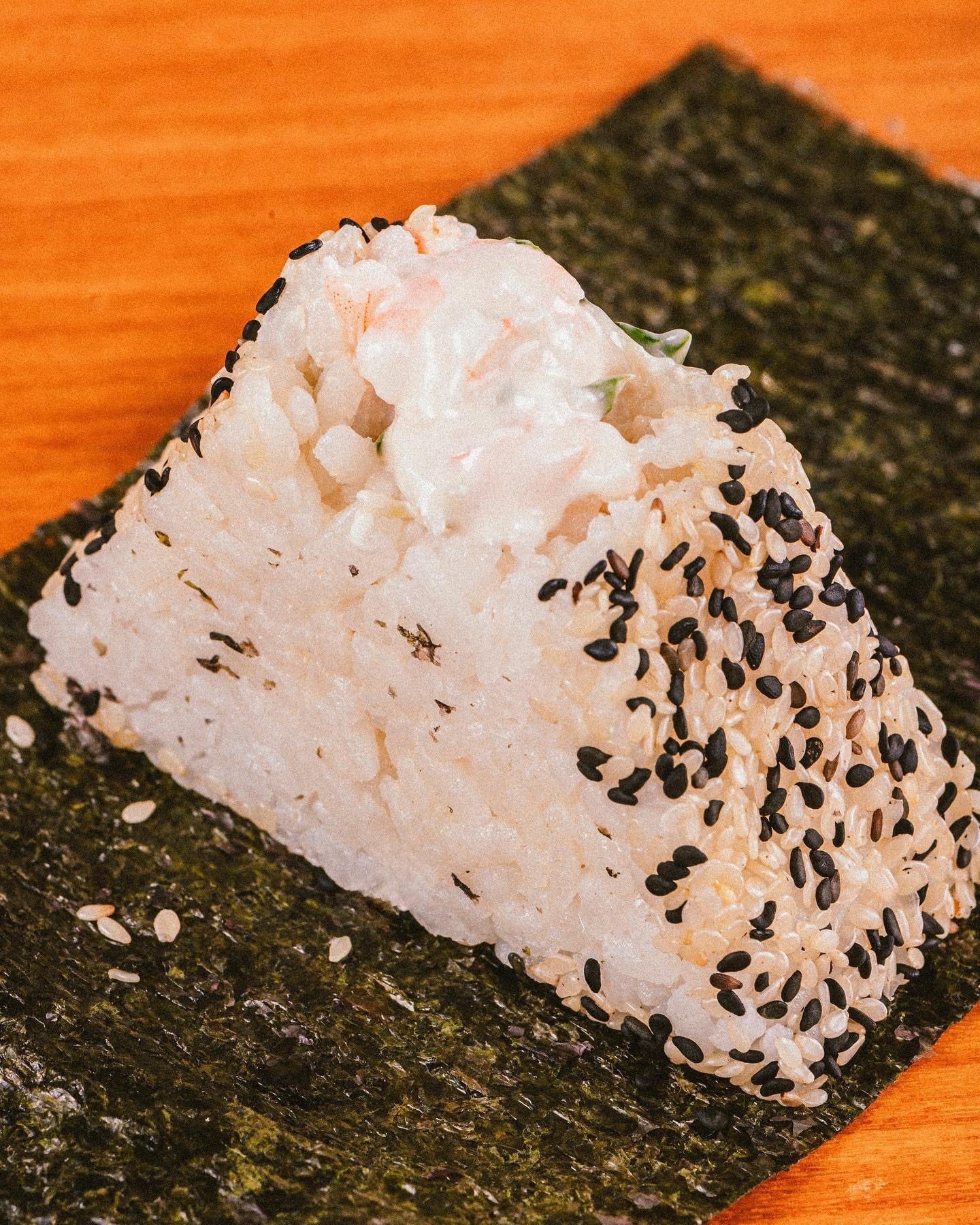 Onigiri de camarão com gergelim sobre a folha de alga