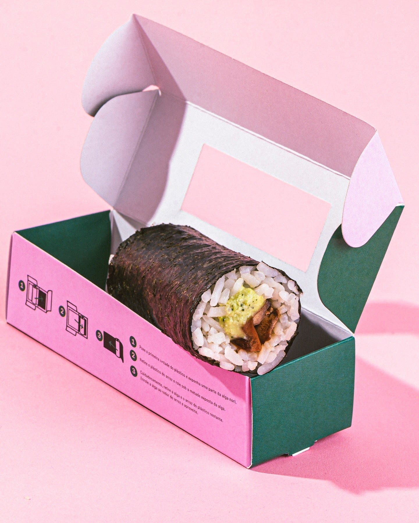 Hand roll dentro da embalagem exclusiva aberta, sobre fundo rosa